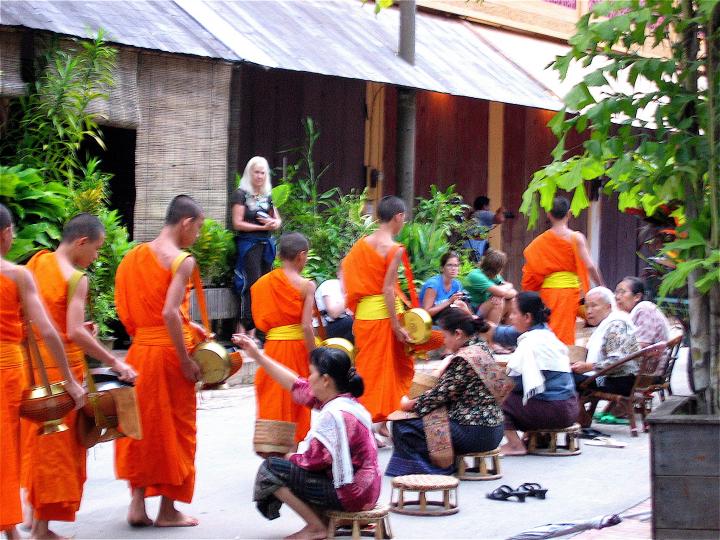 Monks are given rice by faithful women  on their early morning walk through Luang Prabang