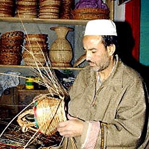 An Indian Kashmiri artesan makes a basket to contain a Kanger, a small clay pot suspended in a basket for carrying burning charcoal underneath overcoats during the winter months.