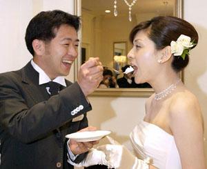 Yuichi Nakasho feeding a piece of cake to his bride, Yuko Sasakawa, during their wedding reception at a wedding hall in Tokyo.