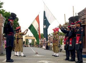 Pakistani paramilitary troopers with their Indian counterparts lower down their respective national flags at the Joint Check Post (JCP) at the Wagah border crossing between Pakistan and India.