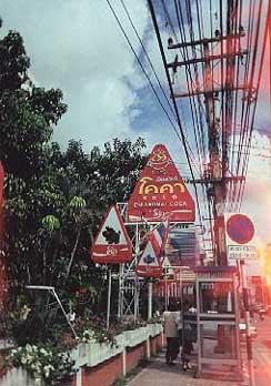 This sign for a Chiang Mai restaurant shows the word 'coca' transliterated into Thai. The four characters are, from left to right, o-k-k-ah; but, because of Thai's placement of vowels, it is read 'kokah.' Transliterations are common for loan words; 'download', for example, is 'daonlot', with a mark over the 'n' to make it silent.