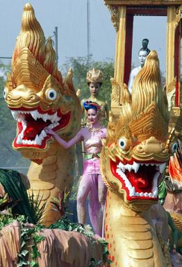 Two Thai woman perform next to naka statues during parade kick off of the Songkran festival in Bangkok. Thailand's famed Songkran water festival, which commemorates the kingdom's traditional lunar new year, usually falls in April.