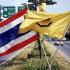 Country and King: As part of the King's birthday celebrations, the national flag of Thailand is flown alongside the yellow flag symbolizing the Thai royalty. Ban Chang, Thailand.