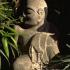 Nestled in a quiet corner of this tiny private garden, a stone Buddha adds an element of contemplative serenity.