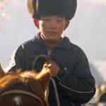 Fur-capped little man in Hemu village, Kenas. Xinjiang province, China.