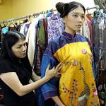 Designer Dang Thi Minh Hanh checks one of her creations with a model at her studio in Ho Chi Minh City, Vietnam.