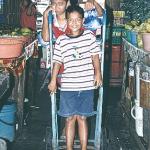 People big and small have their regular duties at the market at Ranong Road. But now and again there's time to play a little. And why not use a sack trolley for a trip around the market?
