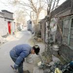 An elderly resident salvages pieces of old furnitures for firewood to warm up his home in one of Beijing's 'hutongs' or alley 24 November 2002. One of the world's best-preserved capitas when the communists took power in 1949, Beijing has changed beyond recognition in recent years, as the city's traditional narrow alleys of single-storey homes, which once filled large sections of its central districts, are fast disappearing in a seemingly frantic rush to turn the capital into another glitzy international metropolis with the same high-rise office towers and shopping malls that can be seen everywhere from Tokyo to Toronto.