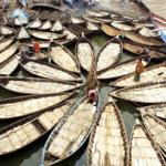 Boatmen make preparations on their vessels before setting out on the Buriganga river in Dhaka.