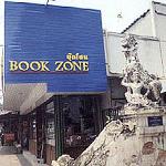 Here is shown a modern bookstore crowding out a deteriorating "singha", or lion, at the entryway to a temple.